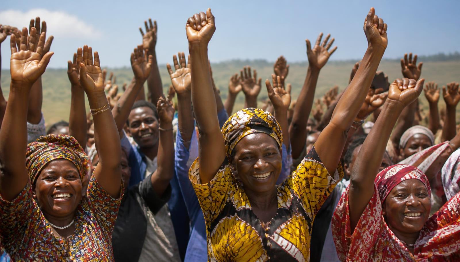 Community members raising their hands in celebration