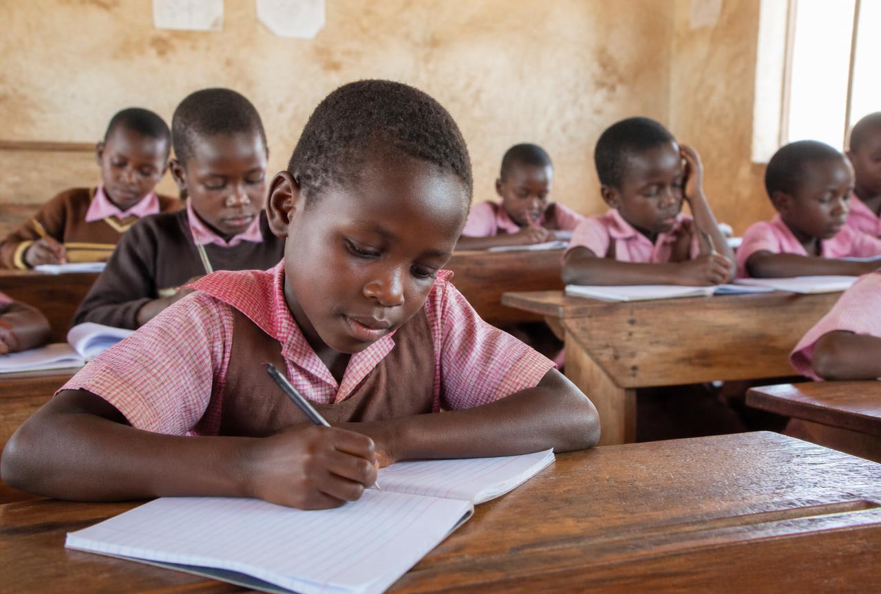Students writing in notebooks in a rural classroom